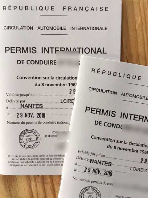 Deux permis de conduire internationaux français posés sur une table en bois